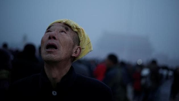 A tourist waits for a flag-raising ceremony at Tiananmen Square amid heavy air pollution in Beijing. (Reuters photo) A tourist waits for a flag-raising ceremony at Tiananmen Square amid heavy air pollution in Beijing. (Reuters photo)