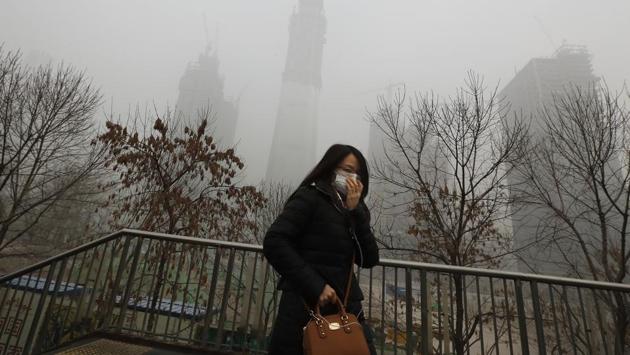 A woman holds her mask to protect herself from air pollution in Beijing. Authorities have shut down schools, ordered thousands of vehicles to go off roads and asked residents to stay indoors. (AP photo) A woman holds her mask to protect herself from air pollution in Beijing. Authorities have shut down schools, ordered thousands of vehicles to go off roads and asked residents to stay indoors. (AP photo)