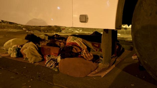 A homeless family finds shelter under a bus near Byculla station in Mumbai. (Pratik Chorge/HT PHOTO)