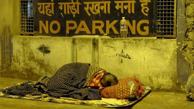 A woman huddles up against the cold, on a footpath in Babughat. (Subhendu Ghosh/HT photo)