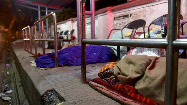 Homeless people sleep at a bus stop near Sultania Hospital in Bhopal. (Mujeeb Faruqui/HT Photo)