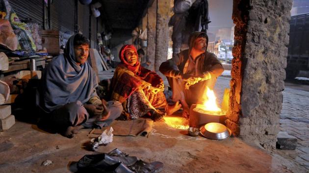 (Left to right) Kallu Ram, Leela Devi and Amar Lal from Rajasthan settle down a cold night on the roadside at Khandsa, Gurgaon. (Parveen Kumar/HT Photo)