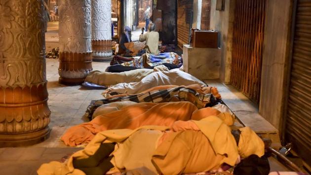 Homeless people sleep near Old Delhi railway station in New Delhi. (Sanjeev Verma/HT PHOTO)
