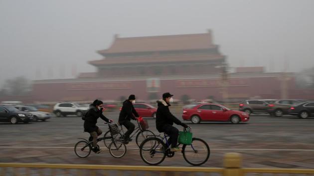 People cycle past Tiananmen Gate in Beijing. (Reuters photo) People cycle past Tiananmen Gate in Beijing. (Reuters photo)