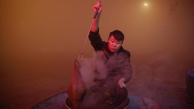 A man cooks in open air as heavy smog blankets Shengfang in Hebei province. (Reuters photo) A man cooks in open air as heavy smog blankets Shengfang in Hebei province. (Reuters photo)