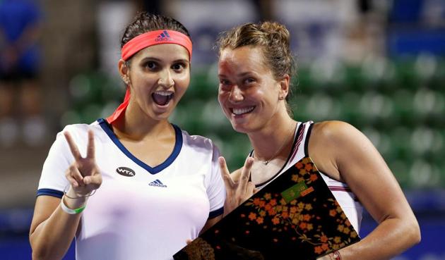 Sania Mirza (L) and Barbora Strycova of Czech Republic pose with their Pan Pacific Open Women's Doubles trophy.(REUTERS)