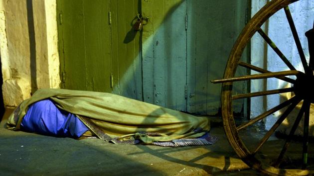 Temperatures in most parts of northern India have been dipping. However, the homeless -- mostly migrants from Bihar and Jharkhand -- are making do with sleeping on cold pavements. Here, a man sleeps at the side of a road in central Kolkata. (Ashok Nath Dey/HT PHOTO)