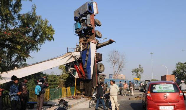 A big crane turned upside down on Wednesday afternoon and remained suspended throughout the day on the busy road near Shahdara drain, adjoining Sector 14-A .(Burhaan Kinu/HT PHOTO)