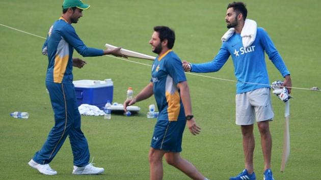 Virat Kohli presents a cricket bat to Mohammad Amir as Pakistan's world T20 captain Shahid Afridi walks past during a training session at the Eden Gardens in Kolkata on March 18, 2016.(AFP) Virat Kohli presents a cricket bat to Mohammad Amir as Pakistan's world T20 captain Shahid Afridi walks past during a training session at the Eden Gardens in Kolkata on March 18, 2016.(AFP)