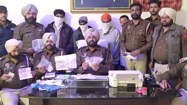 Amritsar (rural) police showing seized Rs 2 lakh in fake currency of new notes and the accused during a press conference on Tuesday.(HT Photo)