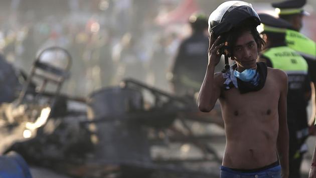 A boy takes his helmet off as he pauses to take a break during the rescue operation. (Eduardo Verdugo/AP)