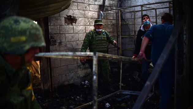 Soldiers and rescuers move a scaffolding during the rescue operations. (Ronaldo Schemidt/AFP)