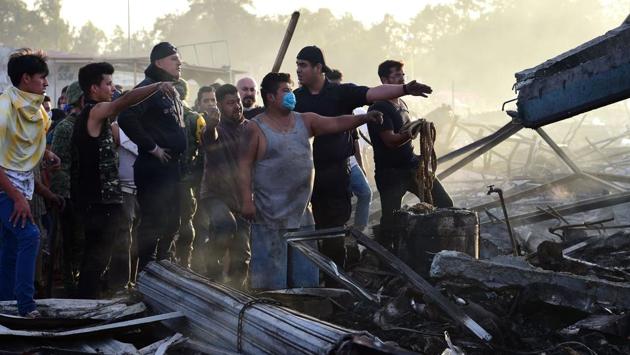 Rescue workers and local residents search amid the debris left after the blast. (Ronaldo Schemidt/AFP)