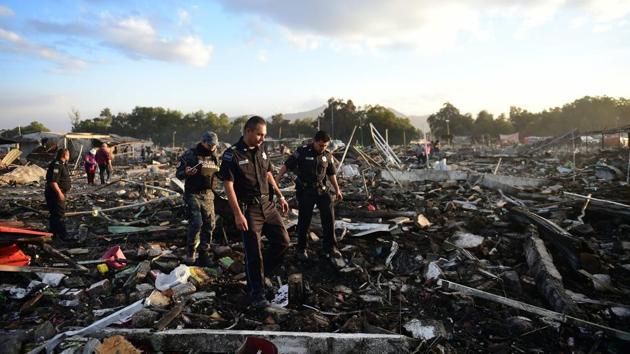 Firefighters work amid the debris during the search operation. (Ronaldo Schemidt/AFP)