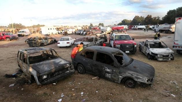 People look inside a burnt vehicle after the explosion. (Edgard Garrido/REUTERS)