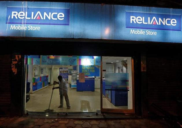 A worker cleans a mobile store of Reliance Communications Ltd, controlled by billionaire Anil Ambani, in Kolkata. (Reuters) A worker cleans a mobile store of Reliance Communications Ltd, controlled by billionaire Anil Ambani, in Kolkata. (Reuters)