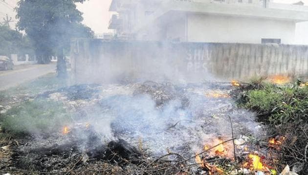 Waste being burned in an open plot in Gurgaon.(HT file)