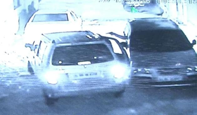 A grab from the CCTV footage that shows an assailant firing at Brij Bhushan from his car on the right. Bhushan was a manager a wine shop run by DTTDC.(HT Photo)