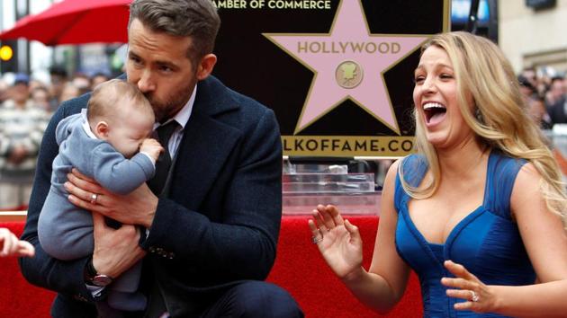 Actor Ryan Reynolds kisses his daughter while posing by his star with his wife Blake Lively.(REUTERS)