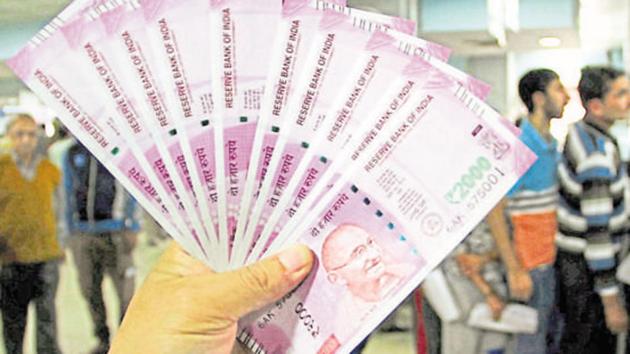 JA bank officer shows new Rs 2000 notes in a bank in Jammu.(PTI)