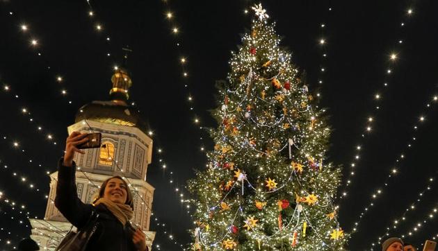 A woman takes pictures next to an illuminated Christmas tree in front of the St Sophia Cathedral in central Kiev, Ukraine. (Reuters photo)