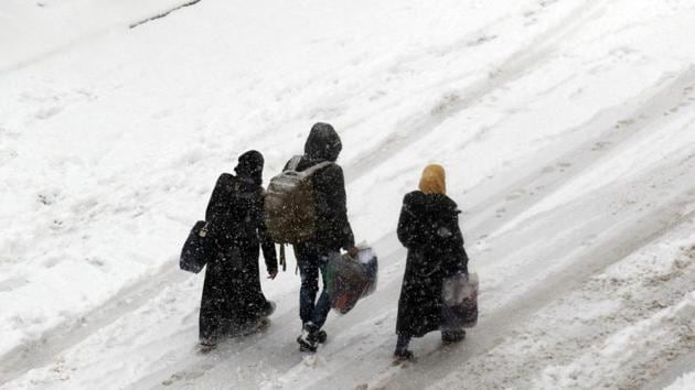 Syrians walk in a snow covered street in the town of Maaret al-Numan, in Syria's northern province of Idlib, on December 21, 2016. At least 25,000 people, including rebel fighters, have left east Aleppo since last week under an evacuation deal that will see the city come under full government control.(AFP Photo)