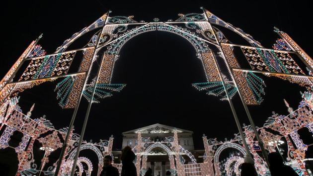 People walk past holiday decorations for the upcoming New Year and Christmas season in front of Bolshoi Theatre in central Moscow, Russia. (REUTERS)