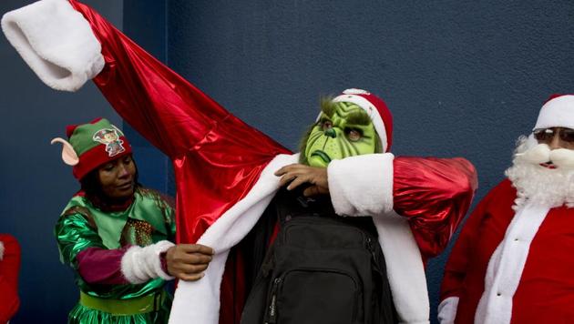 A man is helped to put on his Grinch costume before taking part in the annual Christmas parade in La Paz, Bolivia. Hundreds of people took part in the parade, costumed up as Santa Claus, elves, angels, included floats and marching bands. (uan Karita /AP Photo) A man is helped to put on his Grinch costume before taking part in the annual Christmas parade in La Paz, Bolivia. Hundreds of people took part in the parade, costumed up as Santa Claus, elves, angels, included floats and marching bands. (uan Karita /AP Photo)