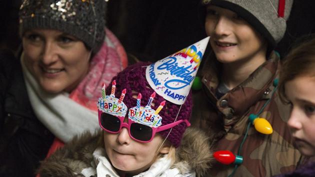 Stella Luken, 5 of Dublin, Ohio, wears a birthday hat and a pair of birthday sun glasses as she waits in line to see Colo. (AP Photo)