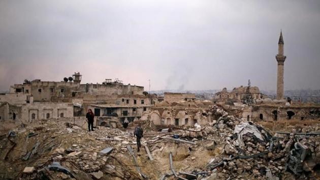 A member of forces loyal to Syria's President Bashar al-Assad stands with a civilian on the rubble of the Carlton Hotel, in the government controlled area of Aleppo, Syria.(Reuters Photo)