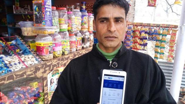 Shabir Ahmed Lone, a grocer in Lanura village in Jammu and Kashmir, has Paytm app on his smartphone but says that villagers are still using cash.(Waseem Andrabi / Hindustan Times) Shabir Ahmed Lone, a grocer in Lanura village in Jammu and Kashmir, has Paytm app on his smartphone but says that villagers are still using cash.(Waseem Andrabi / Hindustan Times)