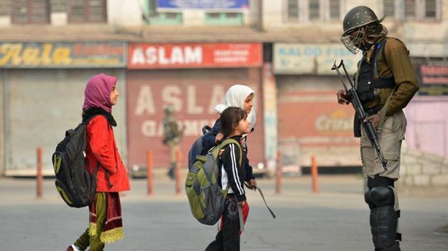 Children walk past paramilitary troopers in downtown Srinagar in November, 2016. (Tauseef Mustafa/HT Photo) Children walk past paramilitary troopers in downtown Srinagar in November, 2016. (Tauseef Mustafa/HT Photo)