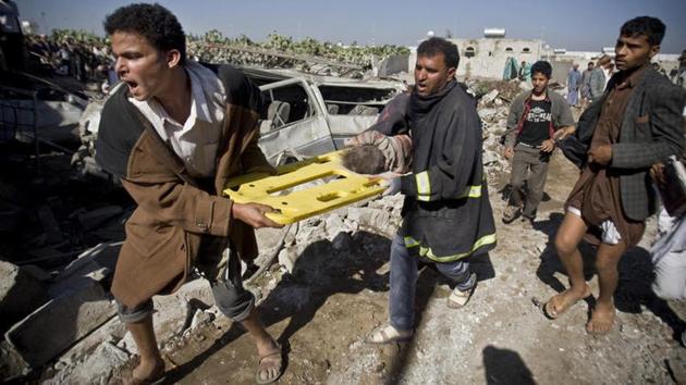 People carry the body of a child they uncovered from under the rubble of houses destroyed by Saudi airstrikes near Sanaa Airport, Yemen.(AP File Photo)