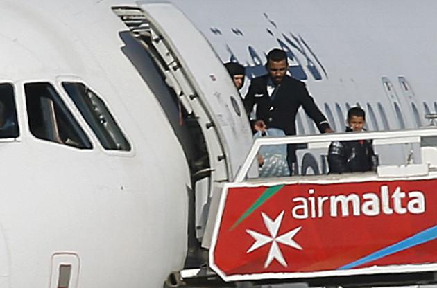 People disembark from a hijacked Libyan Afriqiyah Airways Airbus A320 on the runway at Malta Airport. (REUTERS)