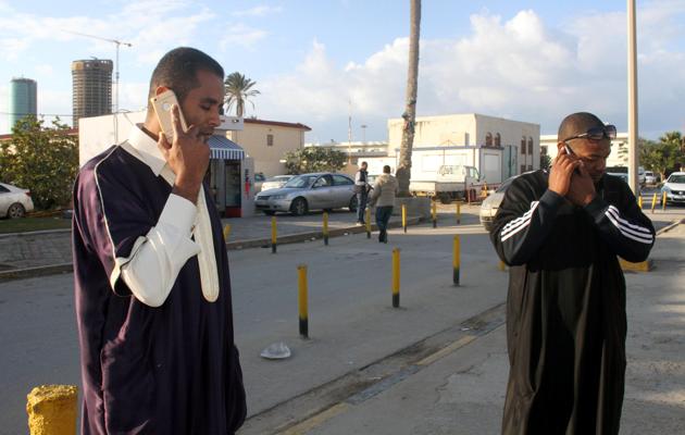 Men wait for their relatives who were abroad an airliner that was hijacked and forced to land in Malta, at Mitiga International Airport, east of Tripoli, Libya. (REUTERS)