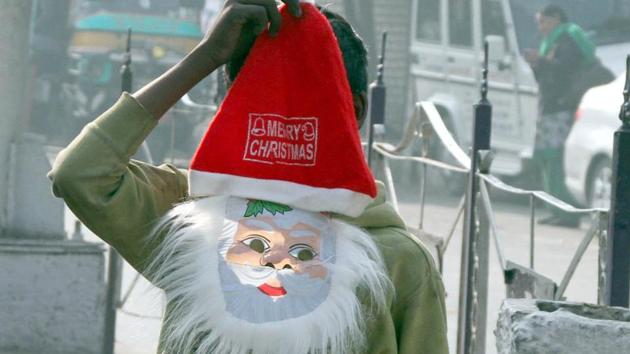 A child selling a Santa mask at Bharat Nagar Chowk in Ludhiana on Friday.(Jagtinder Singh Grewal/HT Photo)