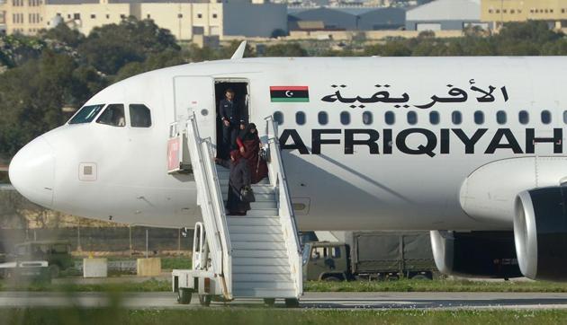 A picture taken on December 23, 2016 in Valletta, Malta, shows a group of hostages being released from the Afriqiyah Airways A320 after it was hijacked from Libya. A man who said he was armed with a grenade hijacked a Libyan plane which landed on Malta Friday with 118 people on board.(AFP Photo)