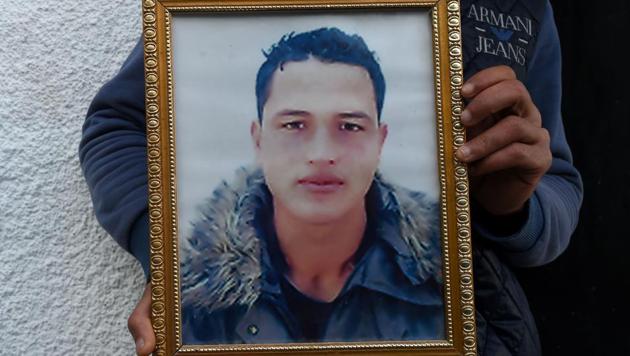 Walid Amri (back), the brother of 24-year-old Anis Amri, the prime suspect in Berlin's deadly truck attack, poses with a portrait of his brother in front of the family house in the town of Oueslatia, in Tunisia's region of Kairouan.(AFP Photo) Walid Amri (back), the brother of 24-year-old Anis Amri, the prime suspect in Berlin's deadly truck attack, poses with a portrait of his brother in front of the family house in the town of Oueslatia, in Tunisia's region of Kairouan.(AFP Photo)