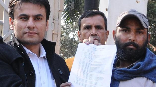 Deepak Kumar(right) being given appointment letter after he climbed down from a mobile tower near the Punjab Bhawan in Sector 3, Chandigarh, on Saturday.(Anil Dayal/HT Photo)