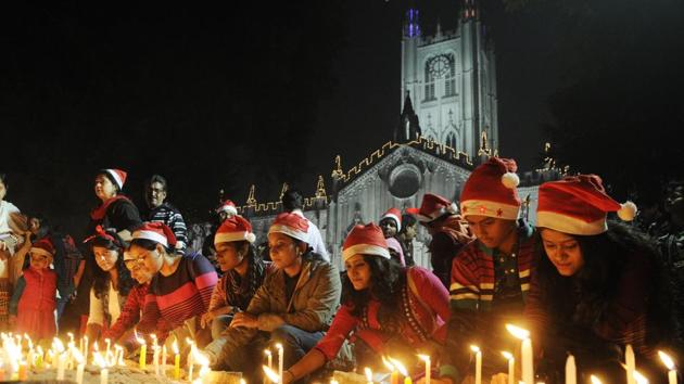 Peoples wearing Santa hats light candles during Christmas Eve celebration in front of St. Paul's Cathedral before Midnight Mass in Kolkata. (Samir Jana/HT Photo) Peoples wearing Santa hats light candles during Christmas Eve celebration in front of St. Paul's Cathedral before Midnight Mass in Kolkata. (Samir Jana/HT Photo)