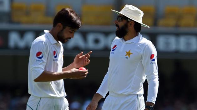 Pakistan's captain Misbah ul-Haq (R) gives instructions to Mohammad Amir (L) during the 3rd day of the 1st Test against Australia.(AFP)