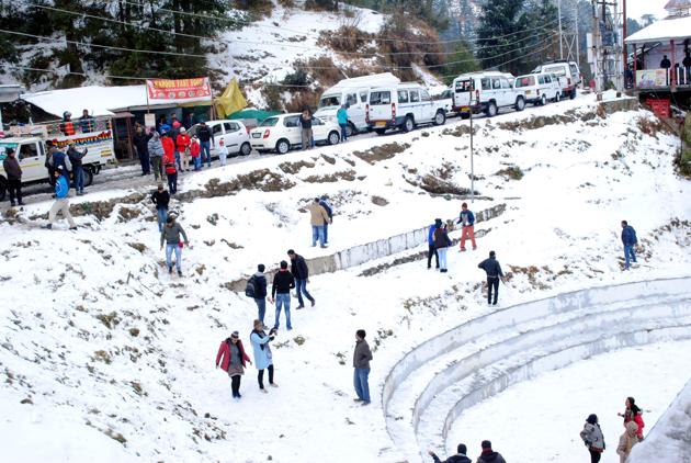 Tourists enjoying fresh snowfall at snow point Ahala on the way to Khajjiar in Chamba District on Sunday. (Shyam Sharma/HT photo)
