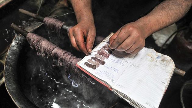 A worker matches the colour of the thread to sample threads. (Waseem Andrabi/HT Photo)