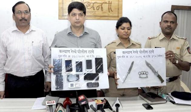 The GRP personnel with the 10 robbed mobile phones and arms used in the crime that they recovered from the accused.(HT Photo)