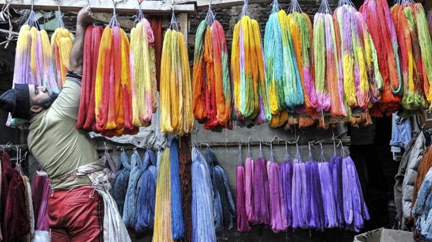 A Kashmiri man adjusts dyed threads as he leaves them to dry. (Waseem Andrabi/HT Photo)