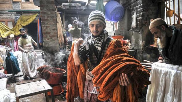 Kashmiri men dye threads at a dyeing centre in Srinagar. The manual dyeing of fabric has been an industry in Kashmir for a long time now. (Waseem Andrabi/HT Photo)
