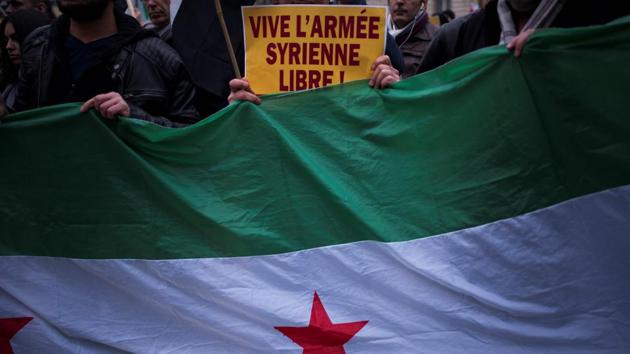 People hold a sign reading 'long live Free Syrian Army' during a protest of Syrian demonstrators near the Iranian embassy against Iranian involvement in the siege of Aleppo. (AFP)
