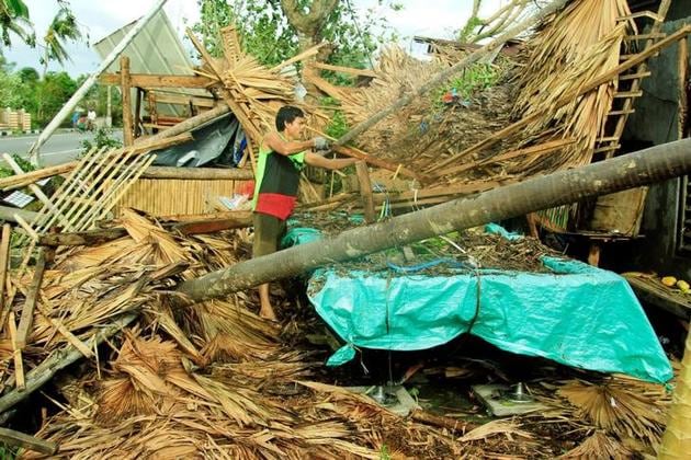 A resident retrieves belongings from his destroyed house after Typhoon Nock-Ten hit Malinao, Albay in central Philippines. (Renellyn Loaquinario/reuters)