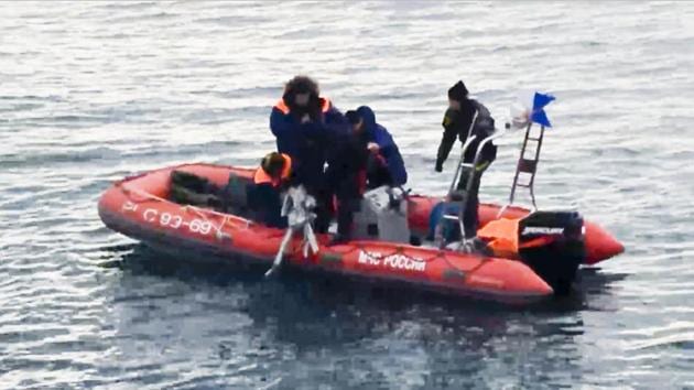 In this frame grab provided by the Russian Emergency Ministry Press Service, ministry employees lift a fragment of a plane outside Sochi, Russia on Monday.(AP) In this frame grab provided by the Russian Emergency Ministry Press Service, ministry employees lift a fragment of a plane outside Sochi, Russia on Monday.(AP)