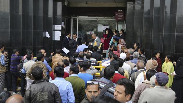 People wait outside a bank to withdraw money in New Delhi.(AP File Photo)